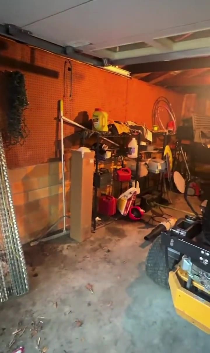 The garage before: cluttered shelving and gear on the floor